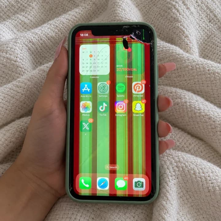 iPhone s počenim sprednjim steklom in zelenimi ter rdečimi črtami na zaslonu.